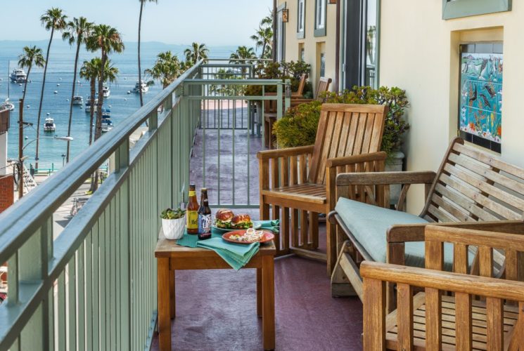 Balcony with wooden patio furniture and view of the harbor