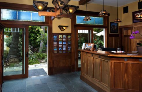 Large reception area with slate tiled floor, wood paneling on the walls, and view of the gardens